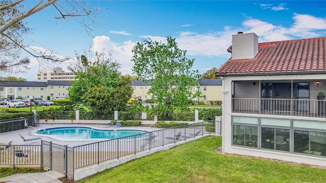 pool featuring a yard, a patio, and fence