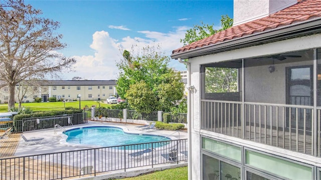 community pool with a patio area, ceiling fan, and fence