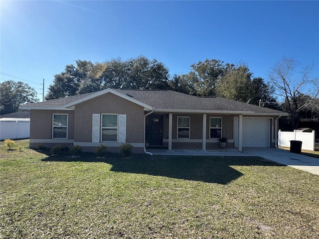 ranch-style home featuring a garage, covered porch, and a front lawn