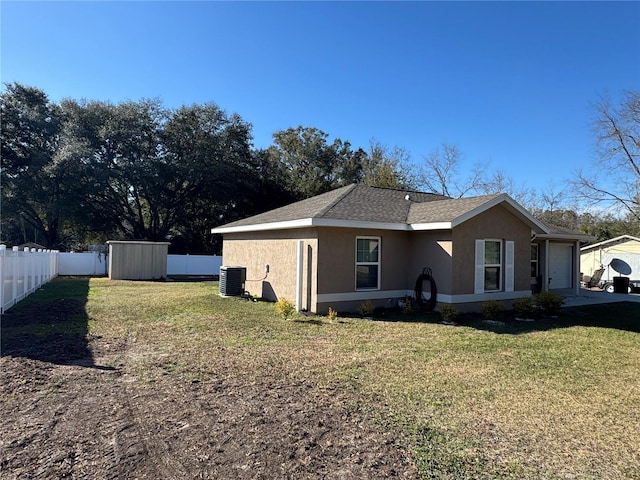 view of property exterior with a storage unit, a garage, a lawn, and central air condition unit