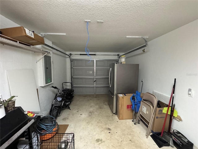 garage featuring electric panel and stainless steel refrigerator