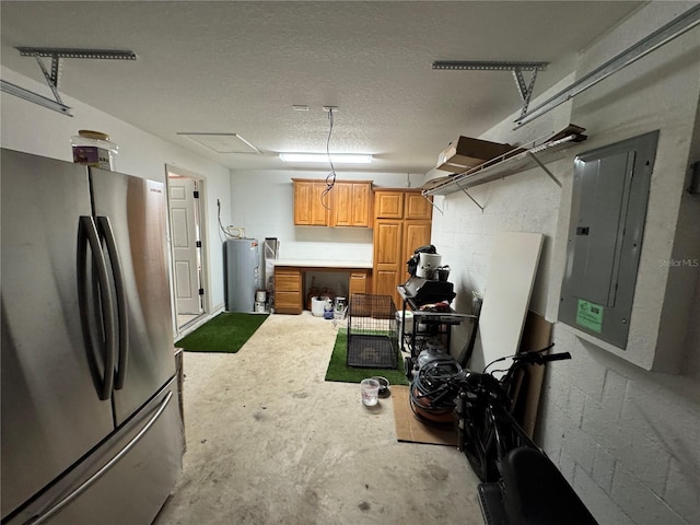 basement featuring electric water heater, electric panel, stainless steel refrigerator, and a textured ceiling