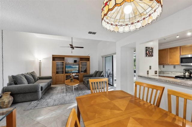 dining space with ceiling fan and light tile patterned floors