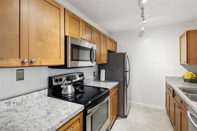 kitchen featuring light tile patterned flooring, ornamental molding, appliances with stainless steel finishes, and track lighting