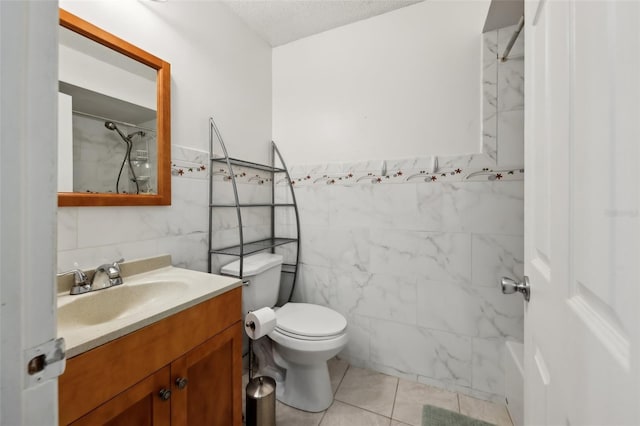 bathroom featuring a shower, tile walls, tile patterned flooring, vanity, and toilet