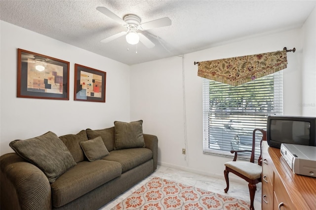 living room with ceiling fan and a textured ceiling