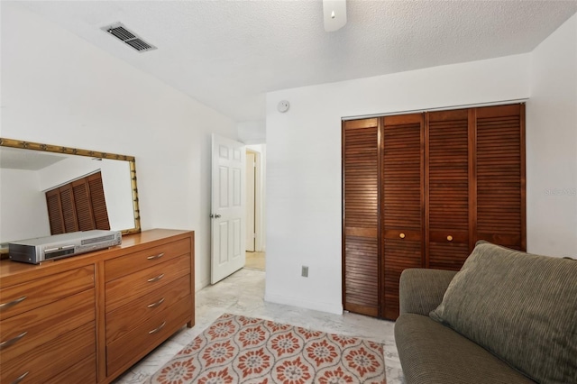 bedroom featuring ceiling fan, a closet, and a textured ceiling