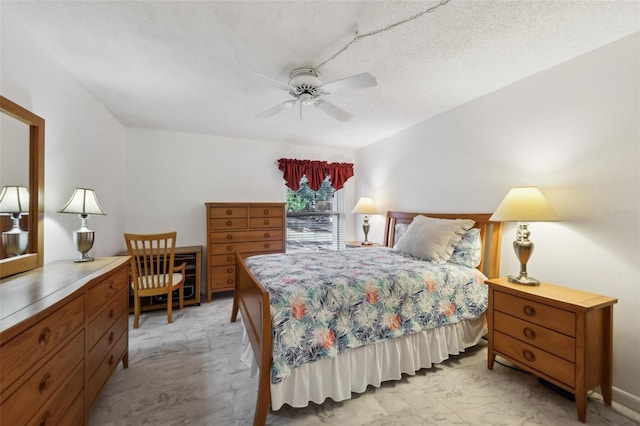 bedroom with ceiling fan and a textured ceiling