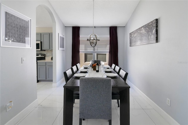 dining room with a textured ceiling and a notable chandelier