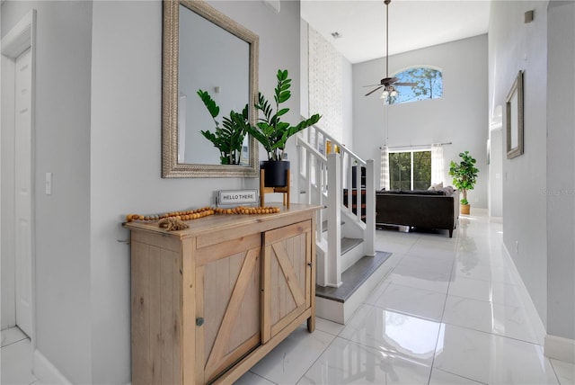 entrance foyer featuring ceiling fan and a high ceiling