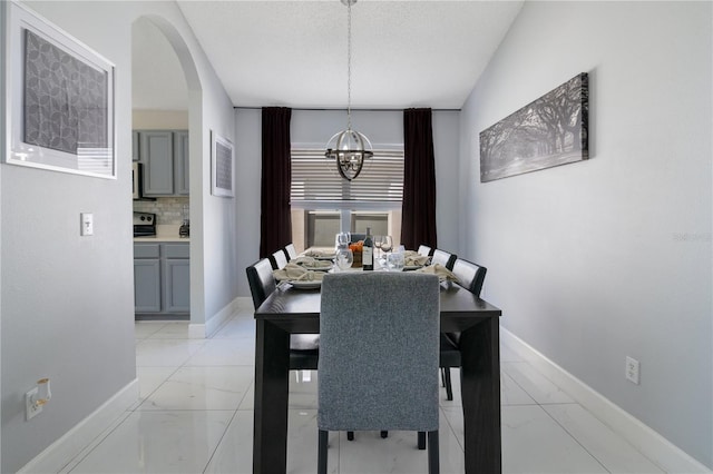 dining space with a notable chandelier and a textured ceiling