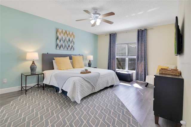 bedroom featuring ceiling fan, dark hardwood / wood-style floors, and a textured ceiling