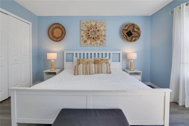 bedroom with dark hardwood / wood-style flooring and a closet