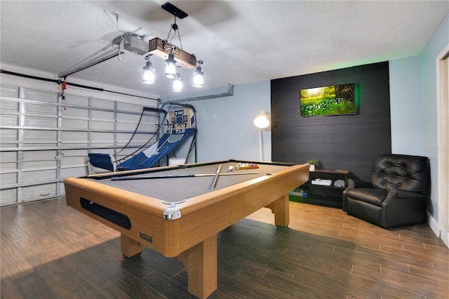 game room with pool table, wood-type flooring, and a textured ceiling