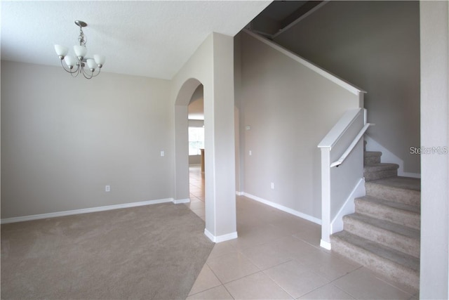 interior space featuring a textured ceiling, tile patterned floors, and an inviting chandelier