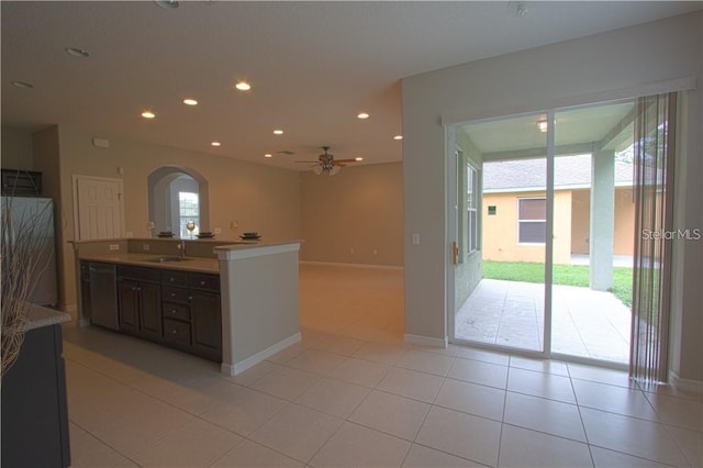 kitchen with light tile patterned flooring, sink, ceiling fan, and dark brown cabinetry