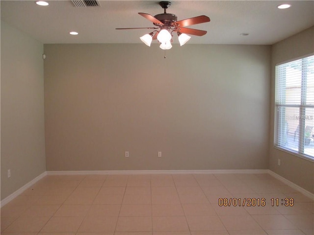 empty room featuring ceiling fan, light tile patterned floors, and a wealth of natural light