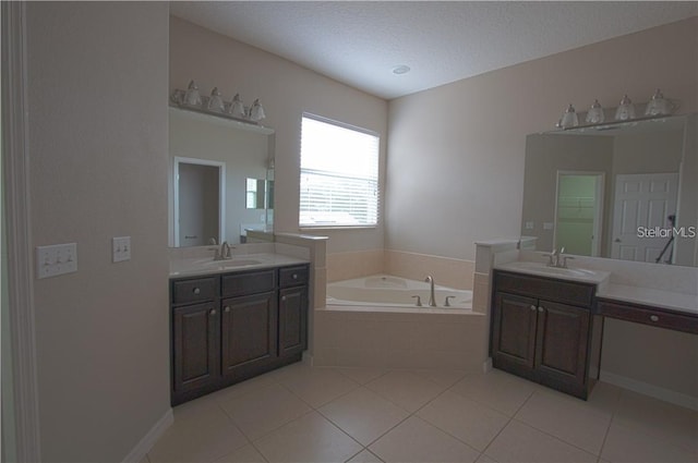 bathroom with vanity, tile patterned flooring, a relaxing tiled tub, and a textured ceiling