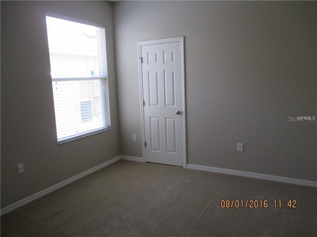 spare room featuring dark colored carpet