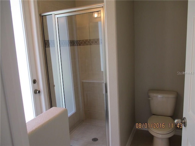 bathroom featuring toilet and an enclosed shower