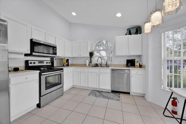 kitchen with sink, decorative light fixtures, stainless steel appliances, and white cabinets