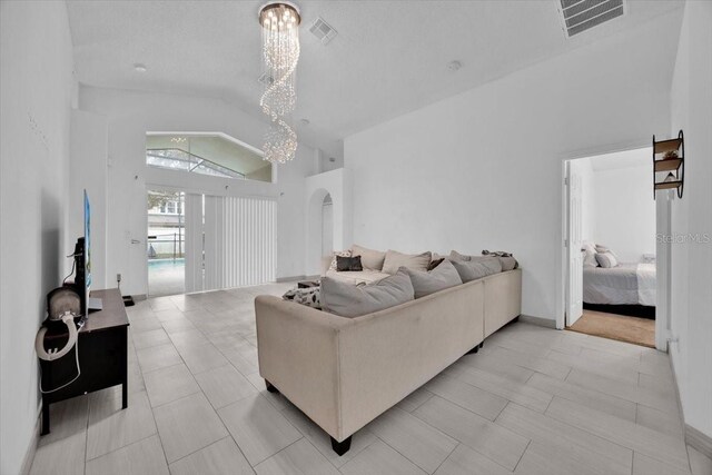 living room with a chandelier and high vaulted ceiling