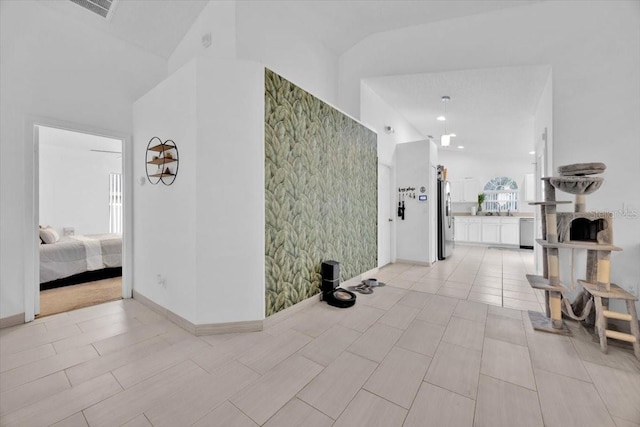 hallway with lofted ceiling and sink