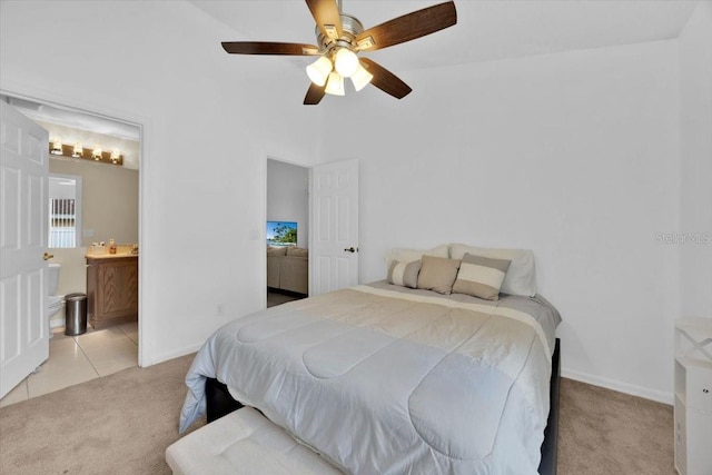 carpeted bedroom with ensuite bathroom and ceiling fan