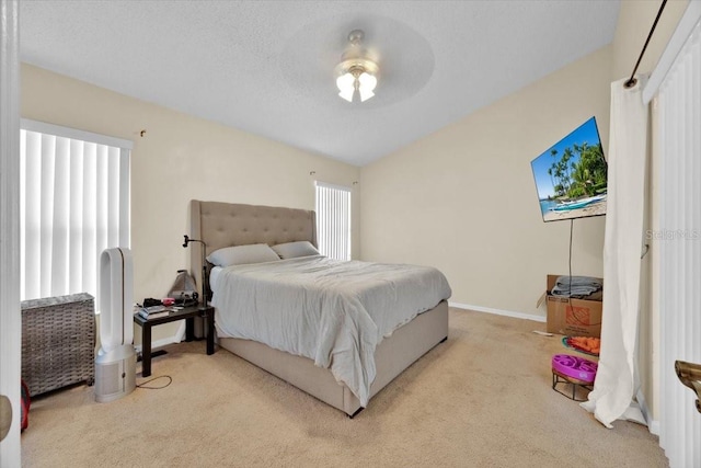 carpeted bedroom with ceiling fan and a textured ceiling