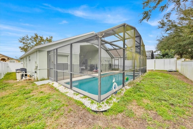 back of property featuring a fenced in pool, a yard, and glass enclosure