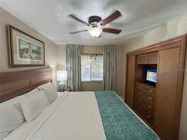 bedroom with ceiling fan and a textured ceiling