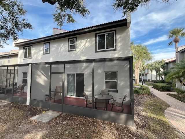 rear view of house featuring a patio area and a sunroom