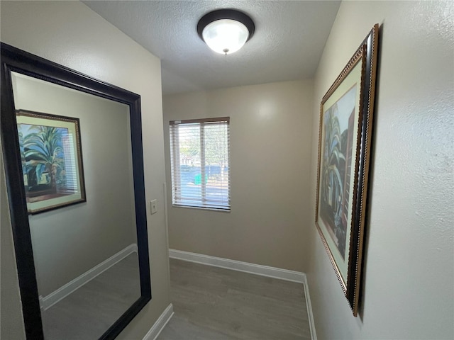 hallway featuring hardwood / wood-style flooring and a textured ceiling