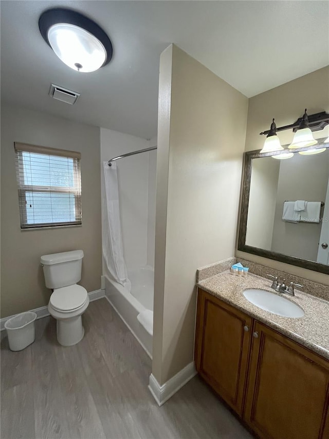 full bathroom with vanity, wood-type flooring, toilet, and shower / tub combo with curtain