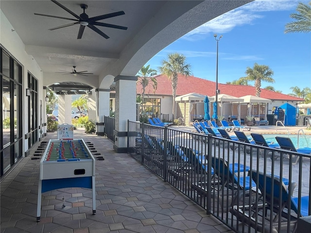 view of patio with ceiling fan and a community pool