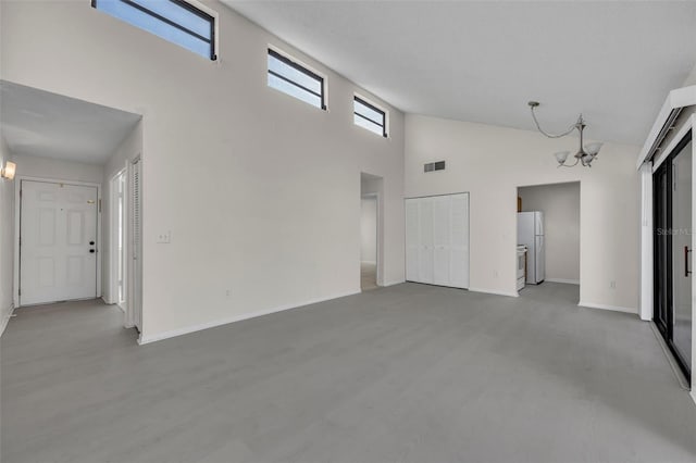 unfurnished living room with wood-type flooring, a chandelier, and high vaulted ceiling