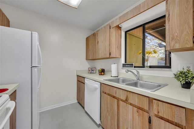 kitchen featuring sink, light brown cabinetry, and white appliances