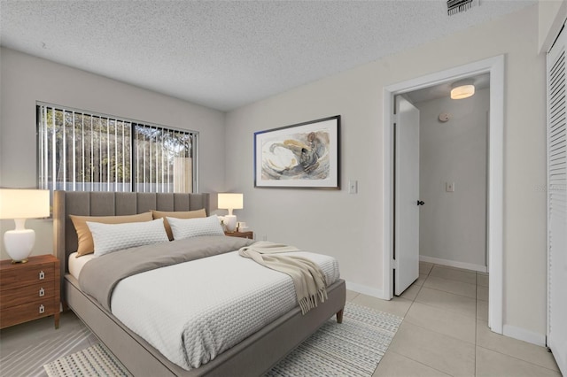 tiled bedroom featuring a closet and a textured ceiling