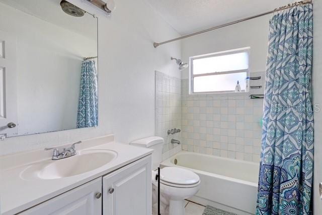 full bathroom featuring toilet, vanity, and shower / bathtub combination with curtain