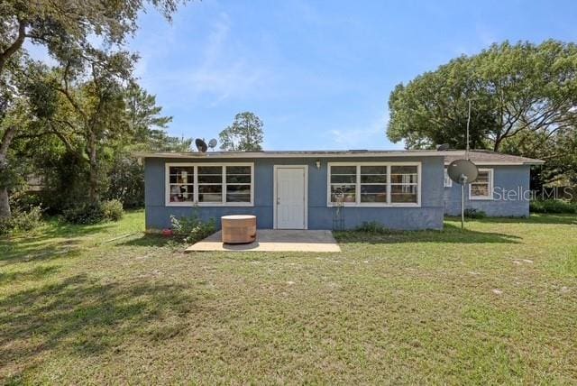 rear view of house featuring a yard and a patio area