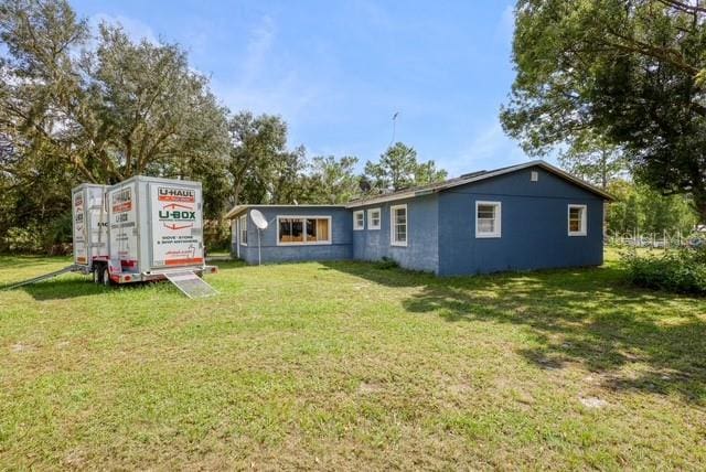 rear view of house featuring a yard