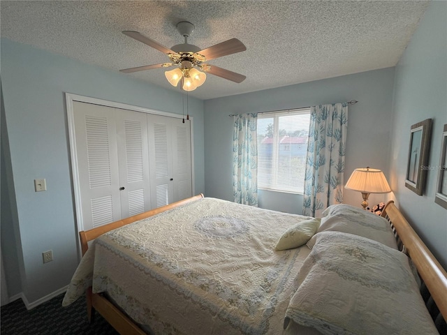 carpeted bedroom with ceiling fan, a closet, and a textured ceiling