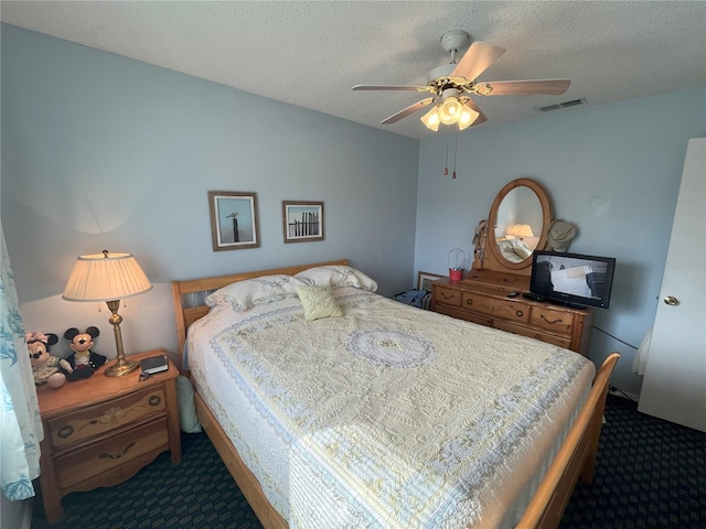 carpeted bedroom with ceiling fan and a textured ceiling