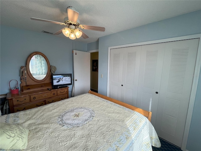 bedroom with ceiling fan, a closet, and a textured ceiling