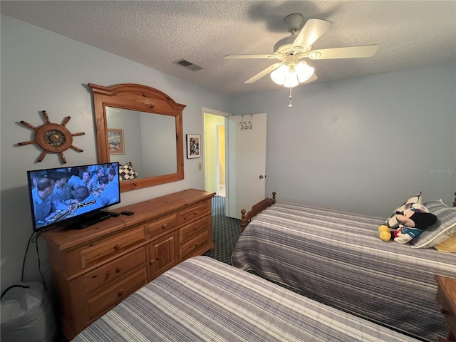 carpeted bedroom featuring ceiling fan and a textured ceiling