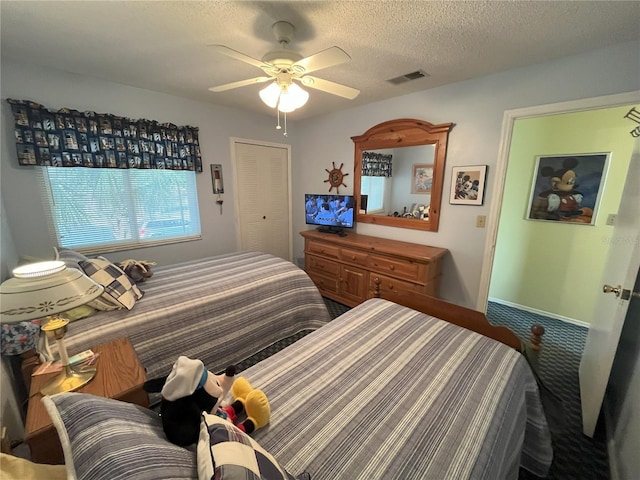 bedroom featuring ceiling fan and a textured ceiling