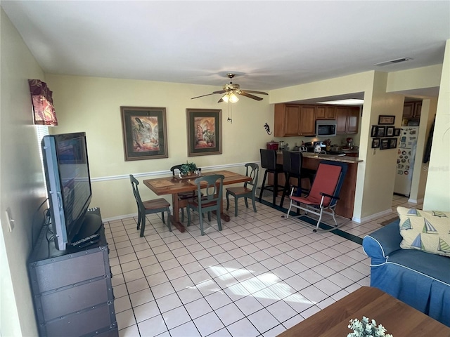 dining area with light tile patterned flooring and ceiling fan