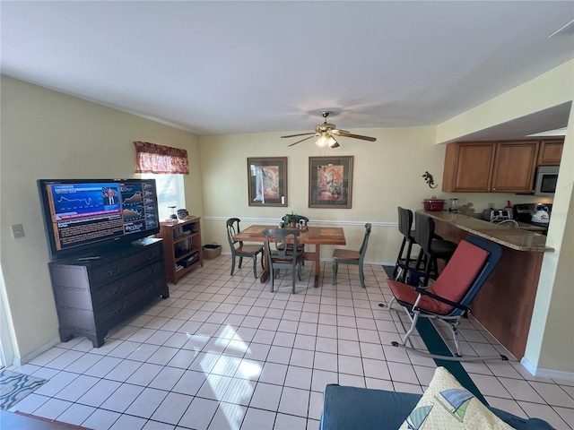 dining space featuring ceiling fan and light tile patterned flooring