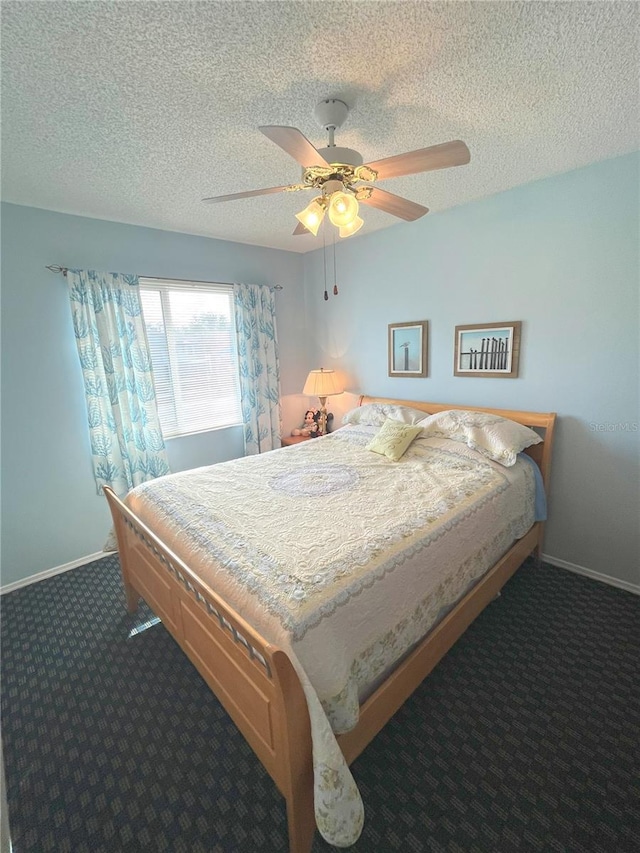 bedroom with baseboards, dark colored carpet, and a textured ceiling
