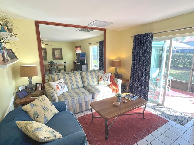 living area with a ceiling fan, visible vents, and light tile patterned floors